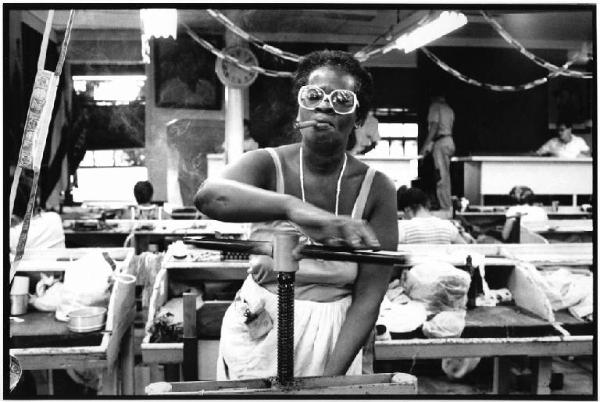 Cuba, La Havana - Fabbrica di sigari, interno - Ritratto femminile - Operaia al lavoro con sigaro e occhiali - Pressa per sigari