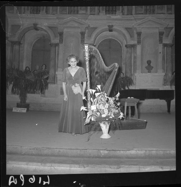 Ritratto femminile - L'arpista Clelia Gatti Aldrovandi durante gli applausi - Arpa e vaso di fiori - Concerto dell'arpista Clelia Gatti Aldrovandi e della cantante Ermanna D'Ettore - Mantova - Teatro Scientifico Bibiena - Interno