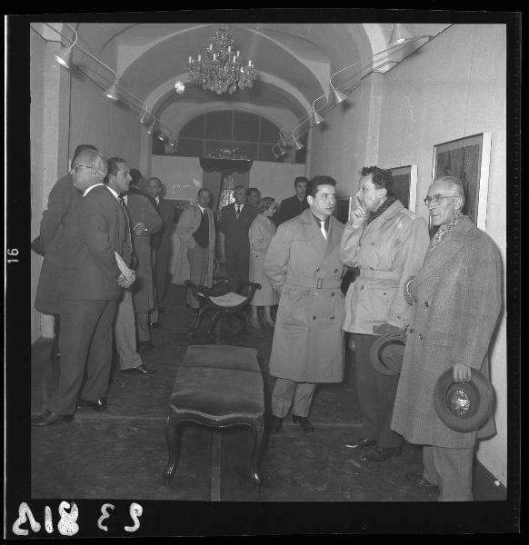Ritratto di gruppo - Il pittore Carlo Dusi con il pubblico nell'atto di osservare i quadri esposti - Inaugurazione mostra di Carlo Dusi -  Mantova - Via Guglielmo Oberdan - Galleria "La Gonzaghesca"