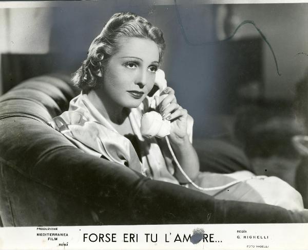 Scena del film "Forse eri tu l'amore" - Righelli, Gennaro, 1939 - Primo piano di Loretta Vinci seduta su divano con la cornetta del telefono all'orecchio.