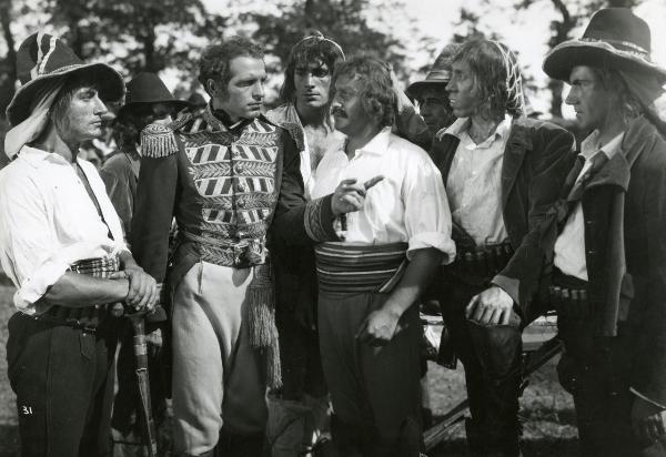 Scena del film "Fra Diavolo" - Zampa, Luigi, 1942 - Enzo Fiermonte è circondato da attori non identificati che lo guardano mentre lui alza un dito verso destra.
