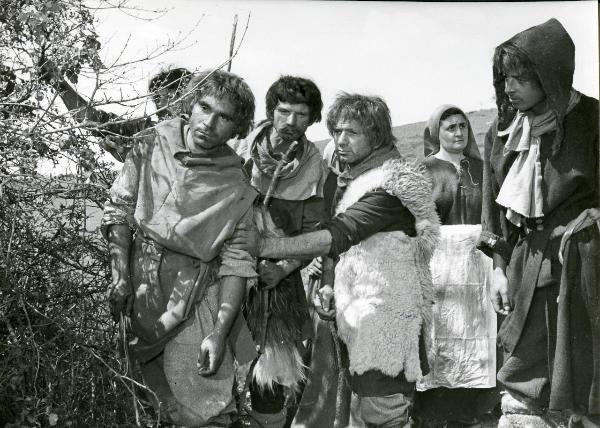 Scena del film "Francesco, giullare di Dio" - Rossellini, Roberto, 1950 - Alcuni attori non identificati, in veste di pastori, guarda oltre le sterpaglie. A destra, un altro pastore li guarda. In secondo piano, una contadina, guarda a destra.
