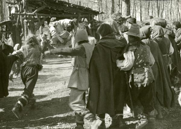 Scena del film "Francesco, giullare di Dio" - Rossellini, Roberto, 1950 - A sinistra, un attore non identificato nelle vesti di pastore lancia un oggetto a un altro attore non identificato di spalle al centro mentre sta saltando. Attorno, una folla.