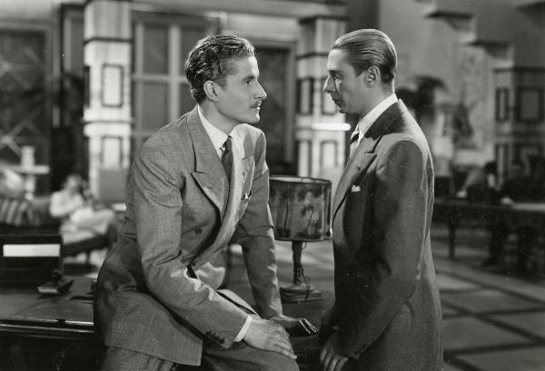 Scena del film "Fuochi d'artificio" - Righelli, Gennaro, 1938 - A sinistra, seduto su una scrivania, Amedeo Nazzari guarda negli occhi Romolo Costa, in piedi a destra.