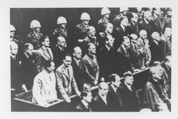 Dopoguerra - Germania, Norimberga - Processo ai principali criminali di guerra, i capi nazisti - Tribunale internazionale, interno - Panche con imputati - Polizia in divisa / Tra gli imputati: fila posteriore: K. Dönitz, E. Raeder, B. von Schirach, F. Sauckel, A. Jodl, F. von Papen, A. Seyß-Inquart, A. Speer, K. von Neurath, H. Fritsche / Tra gli imputati: fila anteriore: H. Göring, R. W. R. Hess, J. von Ribbentrop, W. Keitel, E. Kaltenbrunner, A. Rosenberg, H. Frank, W. Frick, J. Streicher