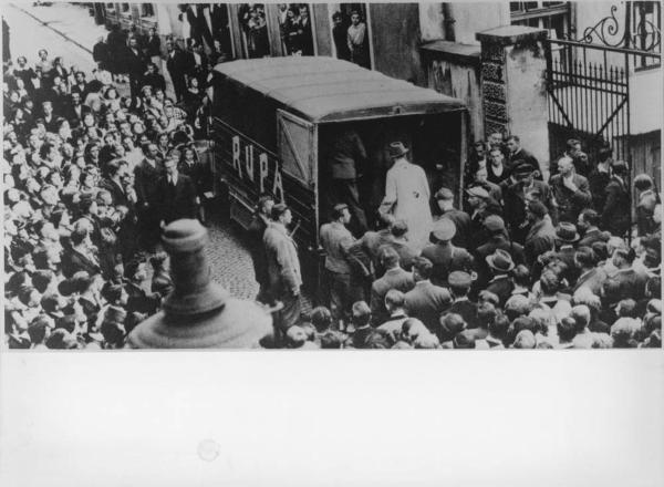 Nazismo - Germania - Arresto di oppositori del nazismo che stampavano materiale di propaganda in una tipografia clandestina - Uomini salgono su camionetta - Folla