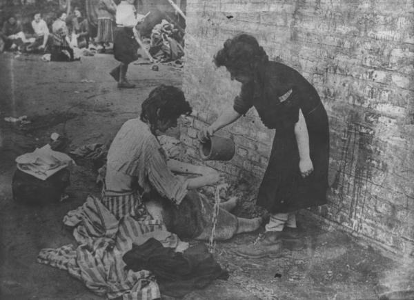 Seconda guerra mondiale - Germania - Campo di concentramento di Bergen Belsen - Nazismo - Liberazione - Ritratto femminile: donna prigioniera sopravvissuta lava le mani - Pigiama a strisce ("zebrati")