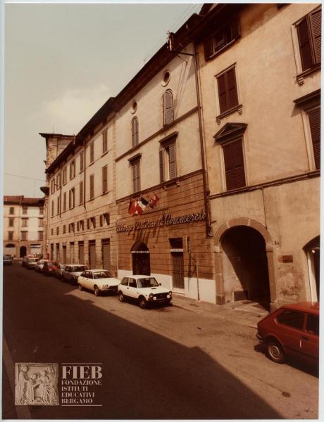 Albergo Commercio - Bergamo - Complesso di Santo Spirito - Esterno: via Torquato Tasso - Automobili parcheggiate - Bandiere - Negozi