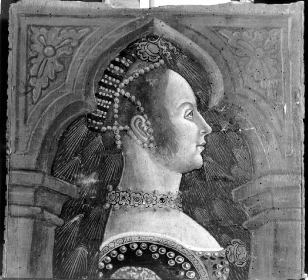 Busto femminile rivolto verso destra con bocchetta a rosette metalliche e perle; capelli raccolti intorno al capo con perle e fascia imbottita