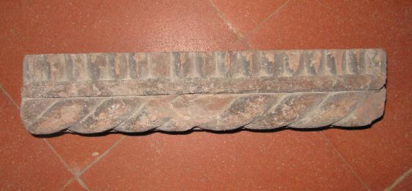 Frammento di bastone a tortiglia con dentelli in terracotta.