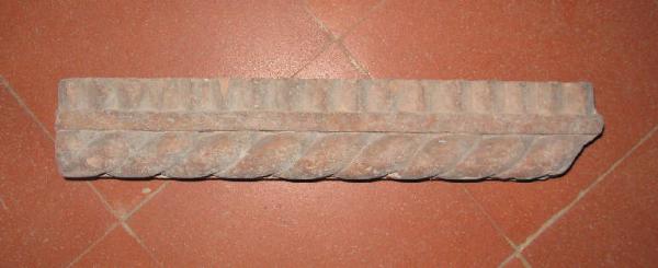 Frammento di bastone a tortiglia con dentelli in terracotta.