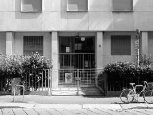 Dettaglio della fascia basamentale su via Sacchi, con in evidenza la soluzione dei pilastri staccati dalle superfici di tamponamento e l'ingresso - fotografia di Sartori, Alessandro (2016)