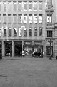 Fotopiano di dettaglio della facciata su via dei Mercanti con la sequenza regolare delle aperture e gli archi ribassati negli sfondati delle finestre - fotografia di Suriano, Stefano (2016)