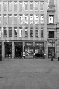 Fotopiano di dettaglio della facciata su via dei Mercanti con la sequenza regolare delle aperture e gli archi ribassati negli sfondati delle finestre - fotografia di Suriano, Stefano (2016)