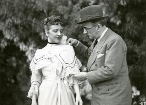 Sul set del film "I due misantropi" - Regia Amleto Palermi, 1937 - Il costumista Gino Sensani sistema l'abito indossato da Nella Maria Bonora.
