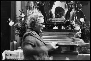 Festa di san Pietro martire in Sant'Eustorgio: donna anziana tocca la base della teca contenente il teschio del santo.