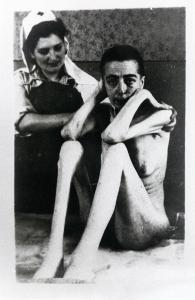 Seconda guerra mondiale - Polonia - Campo di concentramento di Auschwitz - Nazismo - Dopo la liberazione - Infermeria, interno - Ritratto femminile: donna prigioniera scheletrica sopravvissuta e liberata - Infermiera della Croce rossa