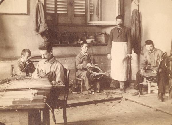 Istituto dei Ciechi di Milano - Scuola di lavori manuali - Laboratorio Zirotti - Interno - Fabbricazione di oggetti in vimini e impagliatura delle sedie - Allievi - Maestro