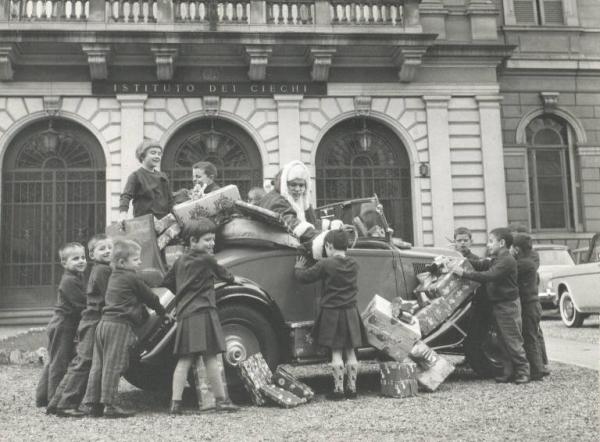 Istituto dei Ciechi di Milano - Cortile davanti all'ingresso - Babbo Natale con auto cabriolet - Bambini - Regali