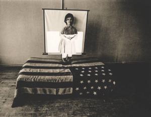 Nana in piedi sulla bandiera americana che copre un letto in una stanza vuota