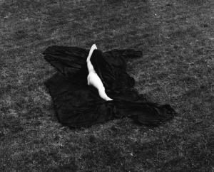Donna nuda distesa su un drappo nell'erba