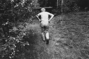 Anziano si dirige verso una baracca in un bosco