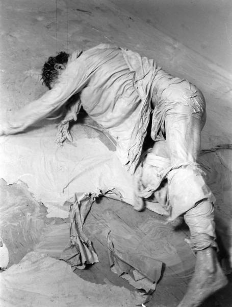 Ana. Performance - Uomo vestito con bende bianche in una stanza vuota - Macchie di pittura a terra e sul corpo