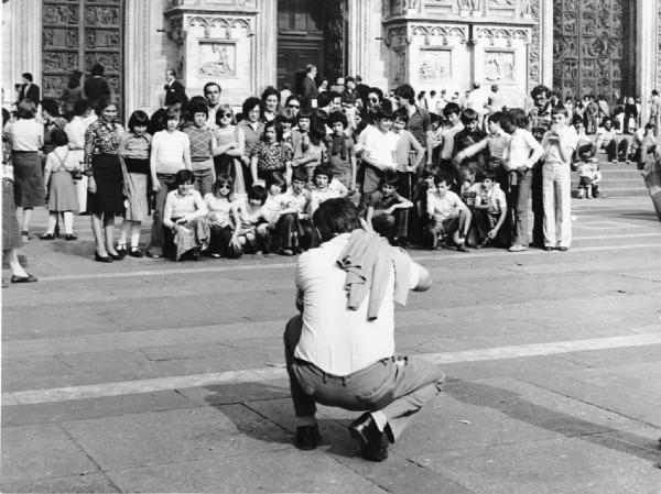 Piazza Duomo: La foto. Milano - Piazza del Duomo - Ritratto di gruppo - Classe di ragazzi con accompagnatori - Uomo, fotografo accovacciato - Foto