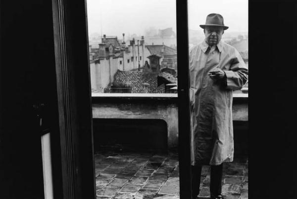 Milano. Ritratto maschile: Eugenio Montale, giornalista, poeta e scrittore fuma su un terrazzo