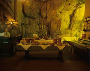 Orvieto dentro l'immagine. Orvieto - Ristorante, interno - Tavolo imbandito con buffet - Uomo alla cassa - Pareti di roccia
