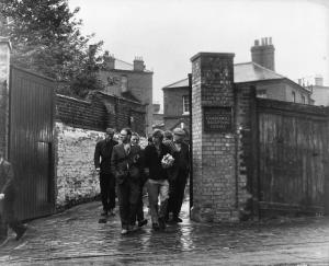 Ritratto. Foto di scena del film Blow-Up. David Hammings e un gruppo di uomini esce dal Camberwell Reception Centre