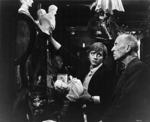 Ritratto. Foto di scena del film Blow-Up. David Hammings e un uomo anziano. Interno con oggetti vari e mezzi busti in marmo