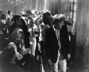 Ritratto. Foto di scena del film Blow-Up. David Hammings durante una festa. Diversi ragazzi che bevono e parlano