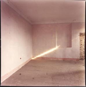 Stanza vuota con raggio di luce su un muro