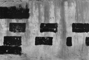 Muro con quadrati di pittura nera e graffitti