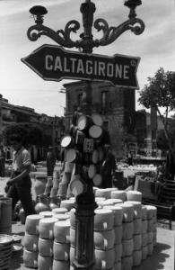 Italia del Sud. Vizzini - mercato - lampione con cartello stradale per "Caltagirone"
