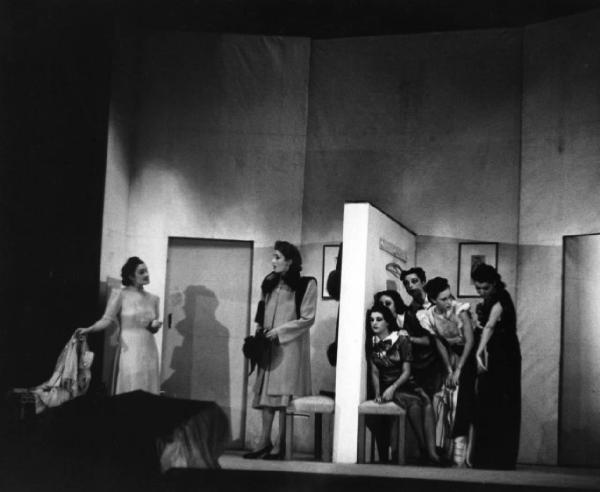 Scena di una rappresentazione teatrale - Gruppo di attrici sedute a fianco di un muro