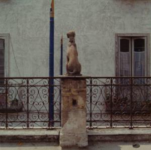 Basamento con scultura di cane - ringhiera in ferro battuto - edificio