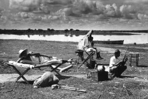 Un gruppo di contadini si riposa in riva a un lago
