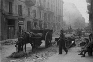 Italia Seconda Guerra Mondiale. Milano. La città dopo il bombardamento del 12 agosto 1943, sfollati abbandonano la città a bordo di un carro trainato da un cavallo che percorre una via ingombra di macerie
