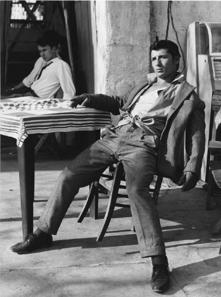 Balera. Italia del Nord - Balera - Cortile interno - Ritratto maschile - Ragazzo seduto a un tavolino - Sigaretta, fumo
