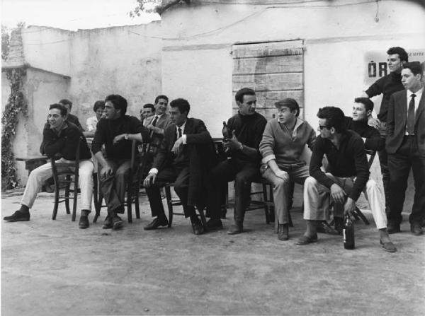 Balera. Italia del Nord - Balera - Cortile interno - Ritratto di gruppo - Ragazzi seduti su sedie vicino alla pista da ballo - Bottiglie di vino, sigaretta, fumo
