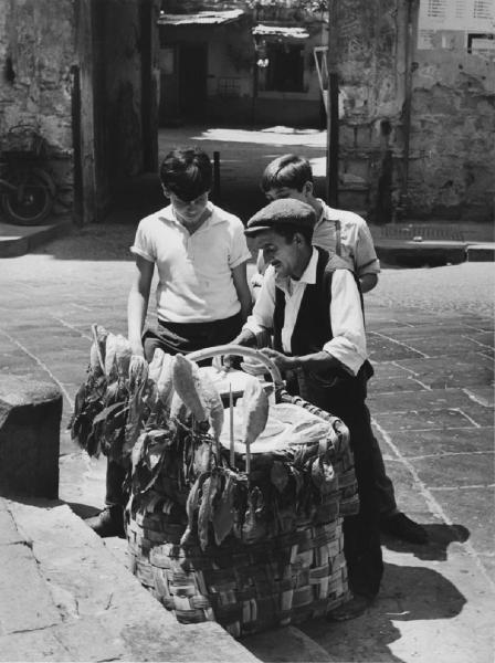 Napoli: Si vende si compra. Napoli - Vicoli - Banchetto street food - Cibo, panini - Anziano con bambini