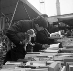 Fiera di Sinigaglia. Milano - Mercatino - Bancarella libri usati - Ritratto maschile - Ragazzo con cucciolo di cane - Lettura