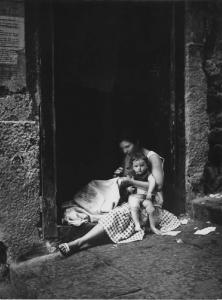 Napoli: Nei Bassi. Napoli - Vicoli - Ritratto di famiglia - Mamma con bambina sulla soglia di casa - Cucito