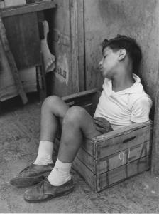 Napoli: Scugnizzi, passatempi. Napoli - Vicoli - Ritratto infantile - Bambino dentro una cassetta di legno - Sonno, riposo