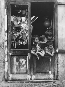Napoli: Scugnizzi, passatempi. Napoli - Vicoli - Ritratto di gruppo - Bambini affacciati a una porta - Oggetti appesi sul vetro