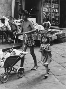 Napoli: Scugnizzi, affetto. Napoli - Vicoli - Ritratto di gruppo - Bambino con neonato in carrozzina e bambina - Passeggiata a piedi scalzi