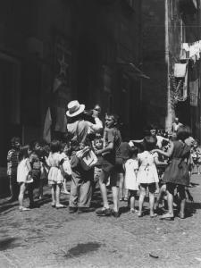 Napoli: Ci si diverte. Napoli - Vicoli - Uomo con la tromba tra bambini - Musica, ballo, divertimento