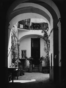 Napoli: Case. Napoli - Ingresso di una abitazione con cortile: arco - Vasi di fiori e piante